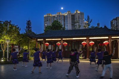市民们晚饭后在公园做各种健身活动的场面，生活的幸福感。