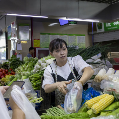 经营户把称好的疏菜装好