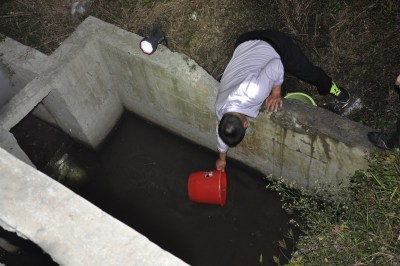 环保执法人员俯下身提水，整个身子几乎失去重心！