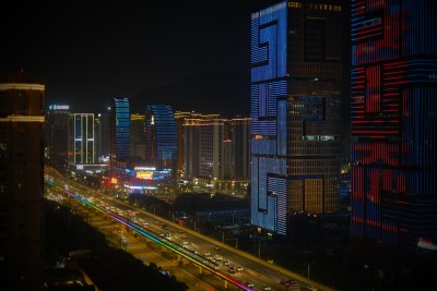 夜幕下的的建设大厦与高架上的车流
