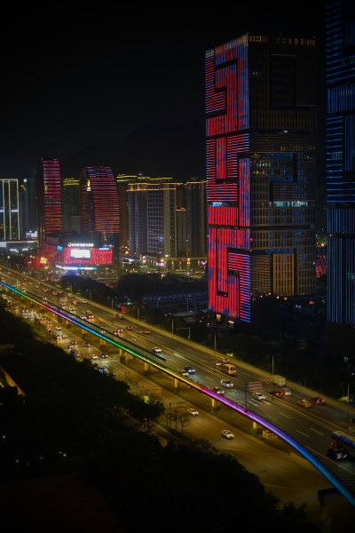 夜幕下的的建设大厦与高架上的车流