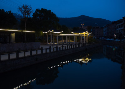 仙岩夜晚的河道边亮起了霓虹灯