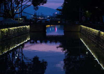 仙岩夜晚的河道边亮起了霓虹灯