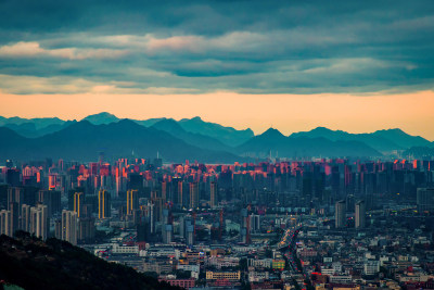 拍摄瓯海区夕阳西下的余光照在梧田都市建筑上的场景，