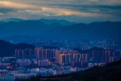 拍摄瓯海区夕阳西下的余光照在牛山都市建筑上的场景，