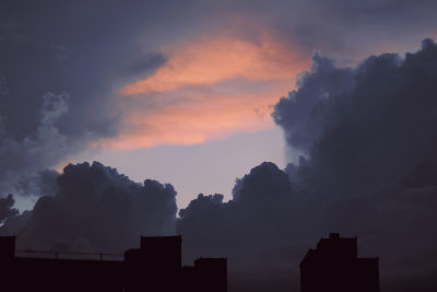 积雨云渐渐汇集，天空中最后一抹倔强的晚霞